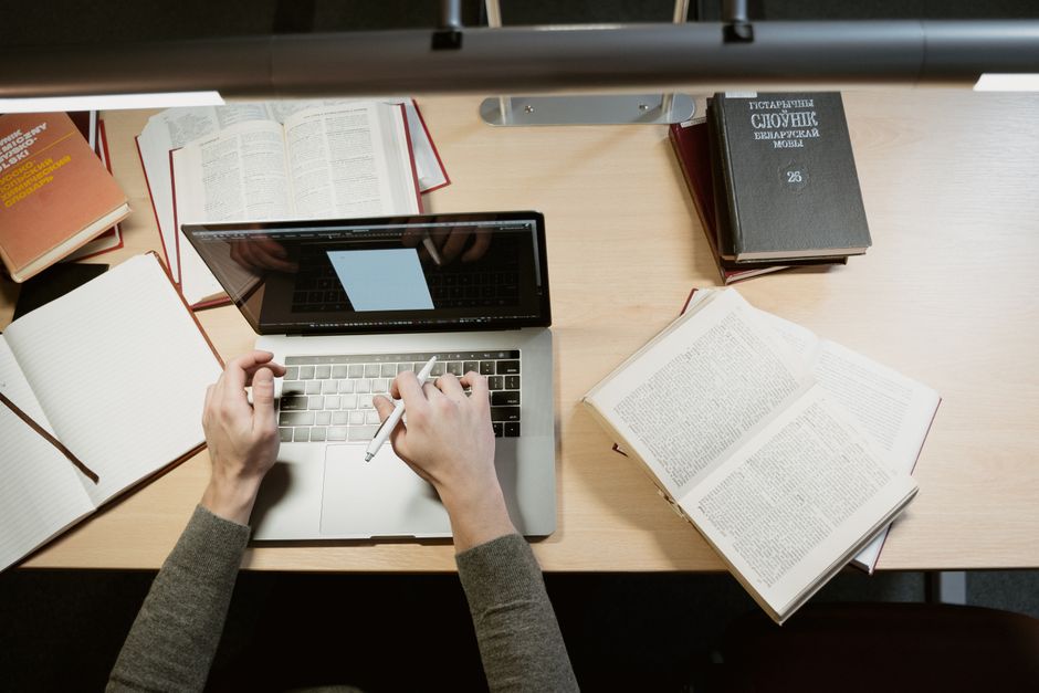 A student studies with a laptop and books, showcasing a learning environment.