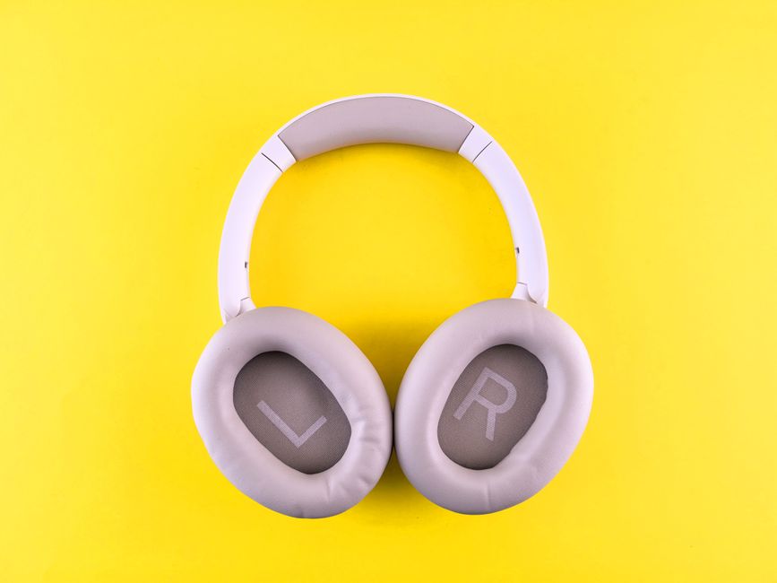 Stylish wireless headphones placed on a bold yellow surface, showcasing modern design and comfort.