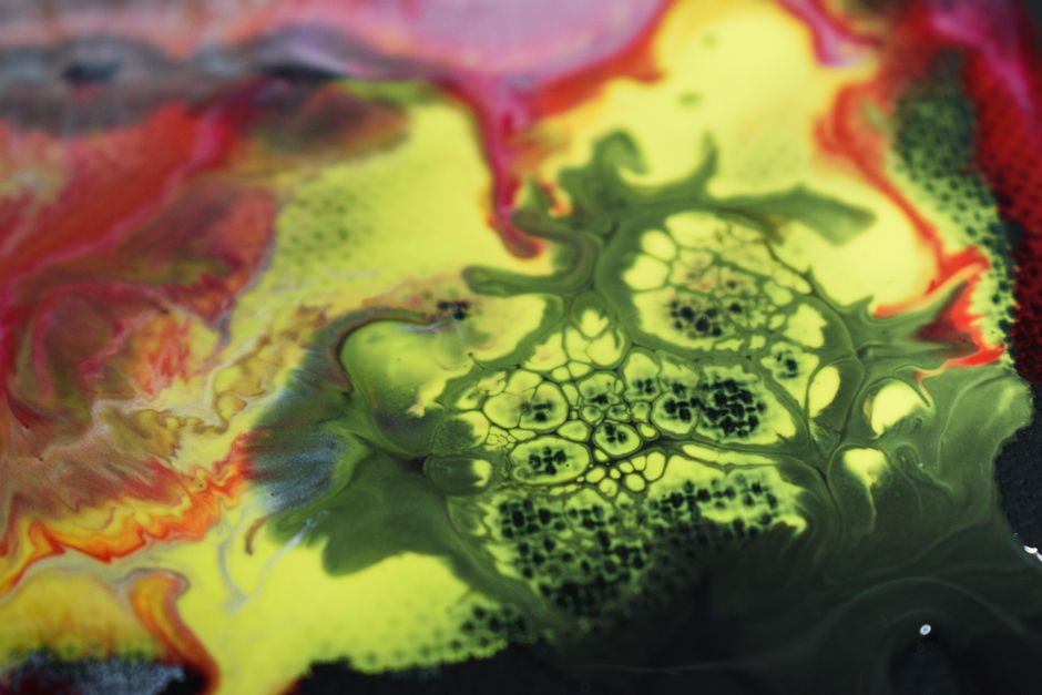 Dynamic abstract fluid art featuring bold red, yellow, and green hues with intricate patterns.